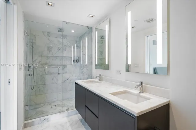 a bathroom with a sink shower and a mirror