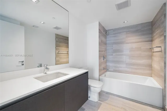 a bathroom with a sink mirror toilet and bathtub