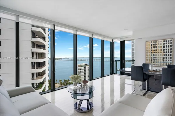 a living room with furniture floor to ceiling window and floor to ceiling window