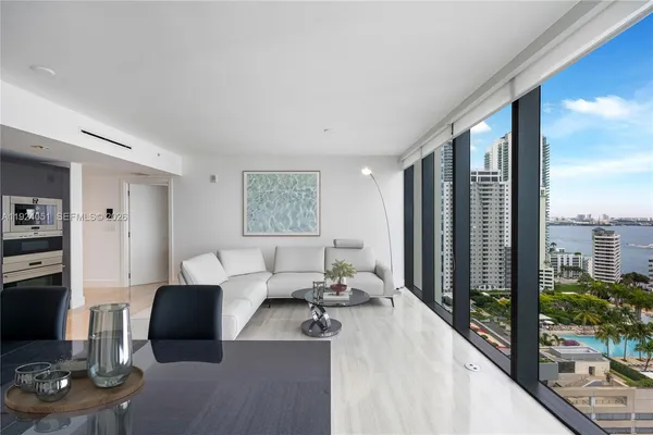 a living room with furniture and a floor to ceiling window