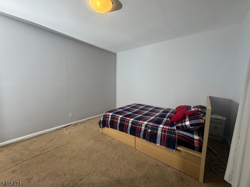 835 Dixie Lane Plainfield, NJ 07062 - Photo 17 of 37 a bedroom with a bed and a chandelier