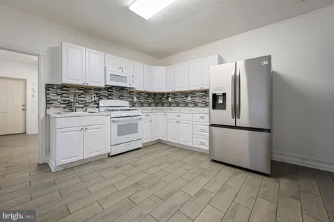 a kitchen with stainless steel appliances a refrigerator sink and cabinets