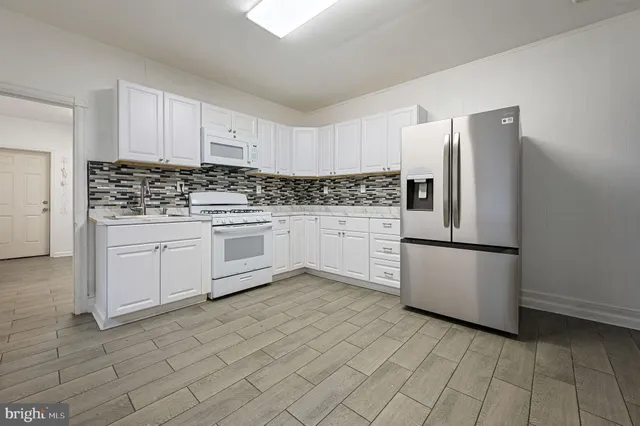 a kitchen with stainless steel appliances a refrigerator sink and cabinets