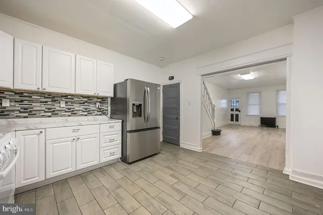 a kitchen with white cabinets and refrigerator