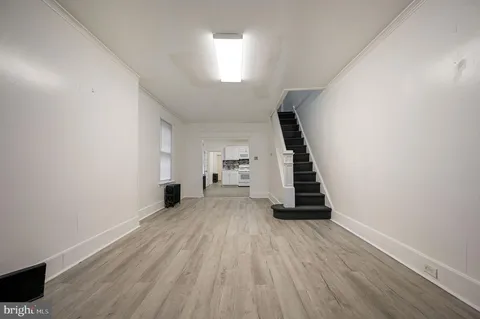 a view of a room with wooden staircase and white walls