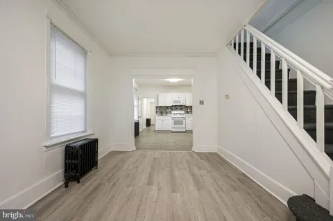 a view of a hallway view with wooden floor and staircase