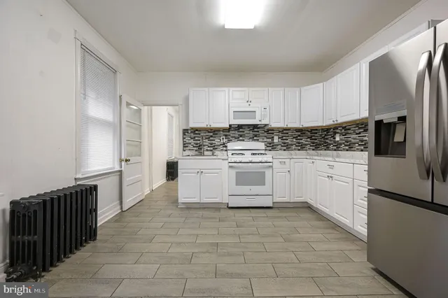 a kitchen with stainless steel appliances granite countertop a stove a refrigerator and a oven