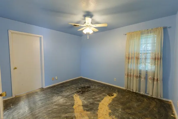 an empty room with closet and a chandelier fan