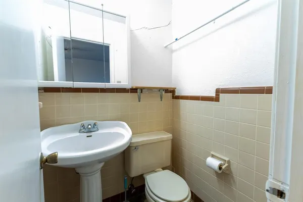 a bathroom with a sink a toilet and mirror