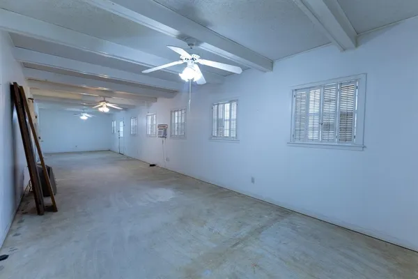 a view of an empty room with a chandelier fan