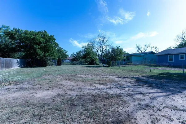a view of a backyard with large trees