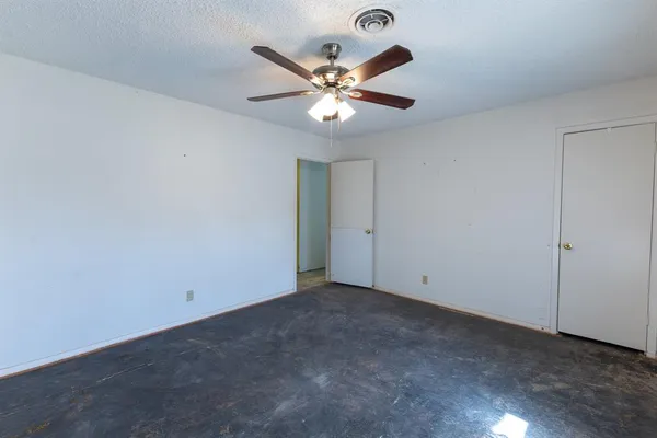 a view of an empty room with a ceiling fan