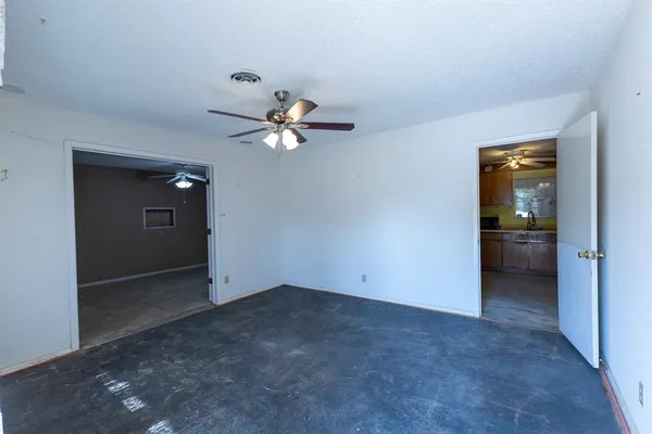 an empty room and chandelier fan in a room