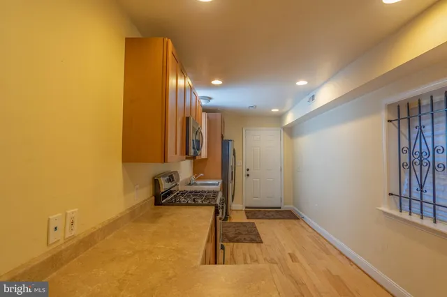 a view of a hallway with wooden floor and staircase