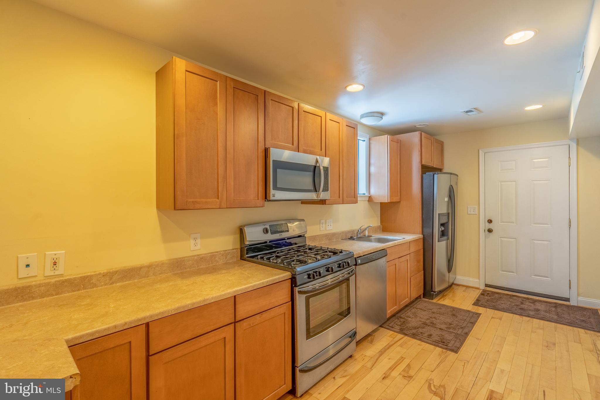 508 Scott Street Baltimore, MD 21230 - Photo 14 of 63 a kitchen with stainless steel appliances granite countertop a stove a sink and a refrigerator with wooden floor