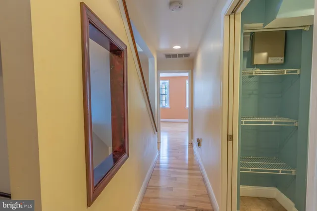 an empty room with wooden floor and mirror