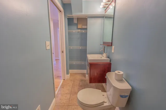 an empty room with wooden floor closet and windows
