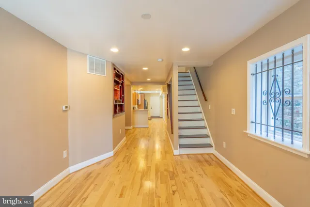 a view of a hallway with wooden floor and staircase