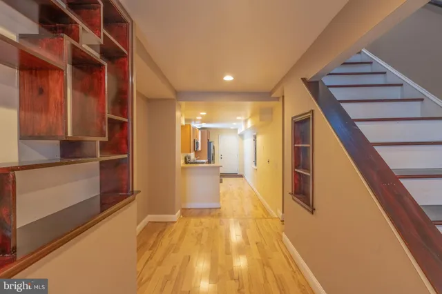 a view of hallway with wooden floor and stairs