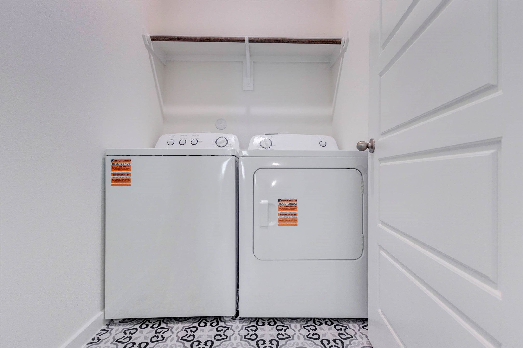 1206 Hemet Court Rosharon, TX 77583 - Photo 14 of 21 Practical utility room with washer and dryer included, patterned tile flooring, overhead hanging rod, and a clean, efficient layout. This dedicated laundry space keeps household tasks tucked away while offering convenience and function near the home’s private living areas, with room for essentials and everyday organization.