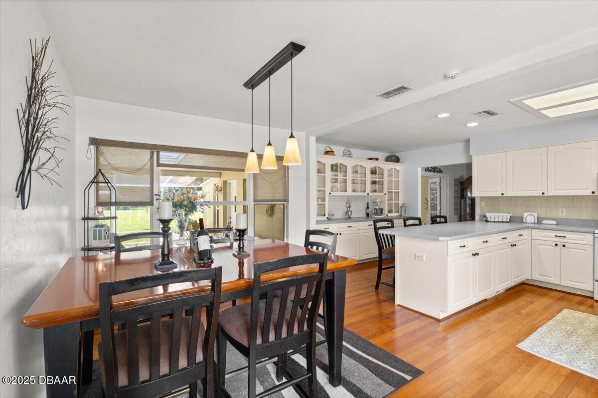 1005 North Kepler Road DeLand, FL 32724 - Photo 23 of 57 a kitchen with stainless steel appliances granite countertop a table chairs sink and wooden floor