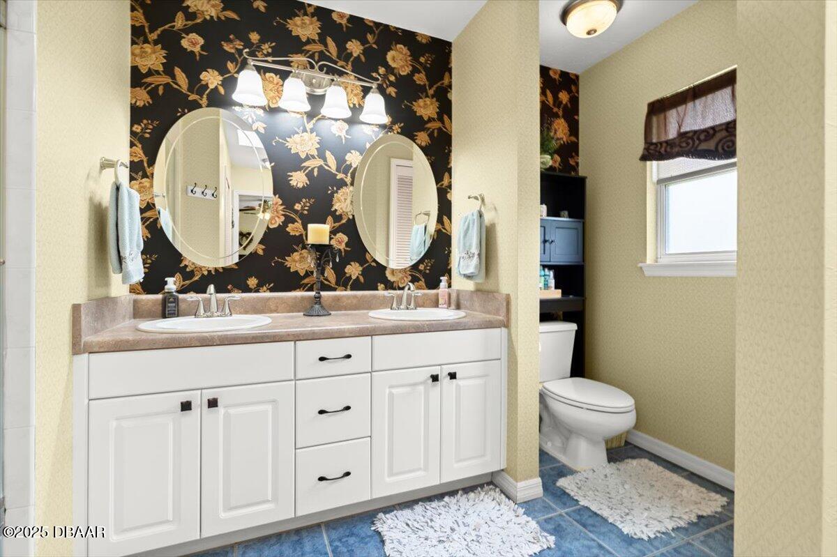 1005 North Kepler Road DeLand, FL 32724 - Photo 33 of 57 a bathroom with a toilet sink and mirror