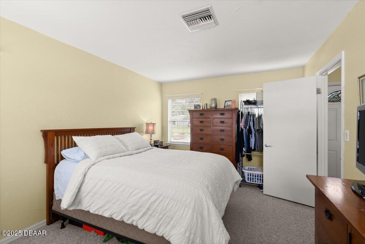 1005 North Kepler Road DeLand, FL 32724 - Photo 43 of 57 a bedroom with a bed a dresser and a large mirror