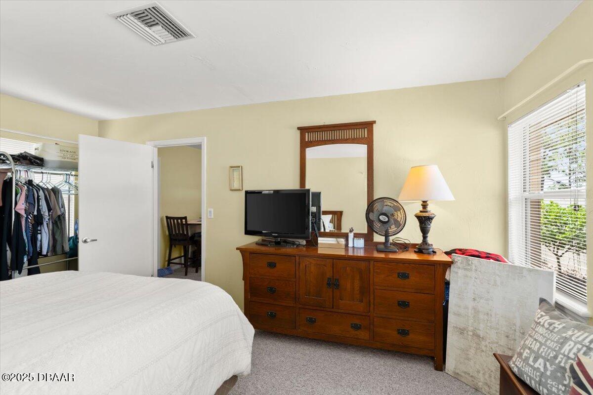 1005 North Kepler Road DeLand, FL 32724 - Photo 44 of 57 a bedroom with a bed and a flat tv screen on dresser