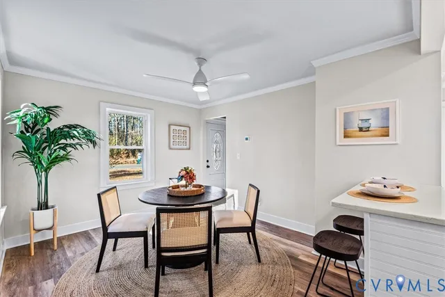 a dining room with furniture potted plants and wooden floor