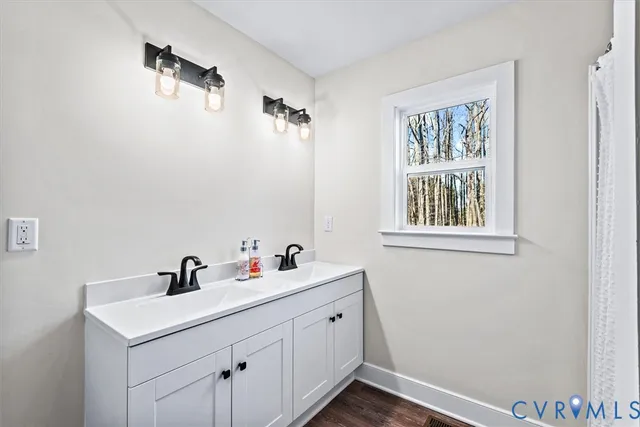 a bathroom with a sink a toilet and shower curtain