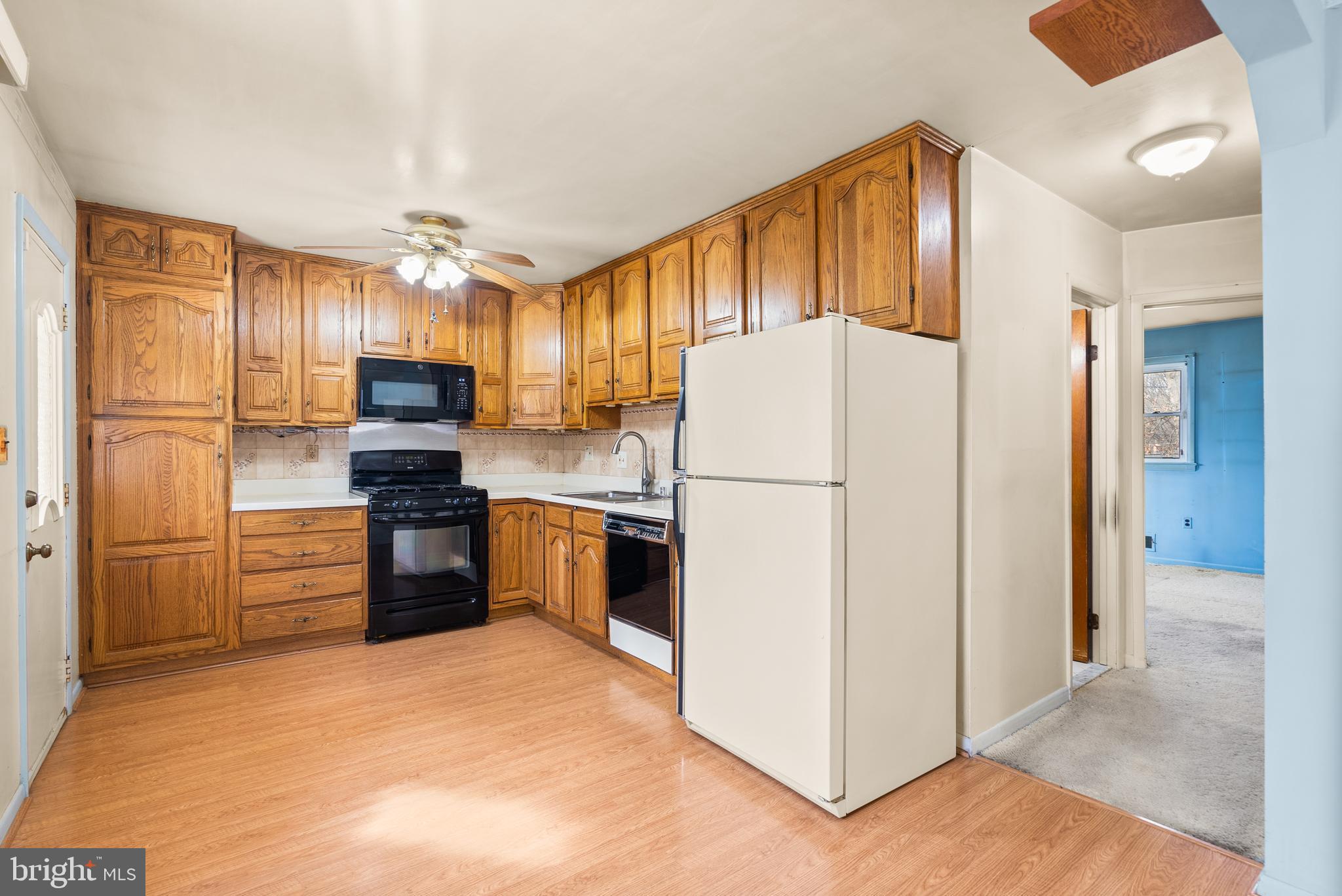 11411 Indigo Drive Beltsville, MD 20705 - Photo 15 of 40 a kitchen with a refrigerator a stove top oven and cabinets