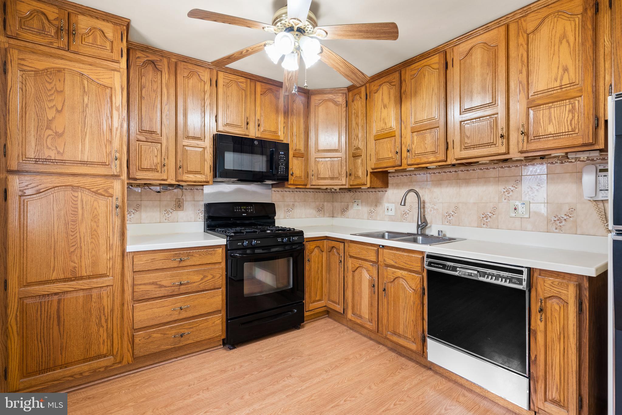 11411 Indigo Drive Beltsville, MD 20705 - Photo 16 of 40 a kitchen with stainless steel appliances granite countertop a stove microwave refrigerator and sink