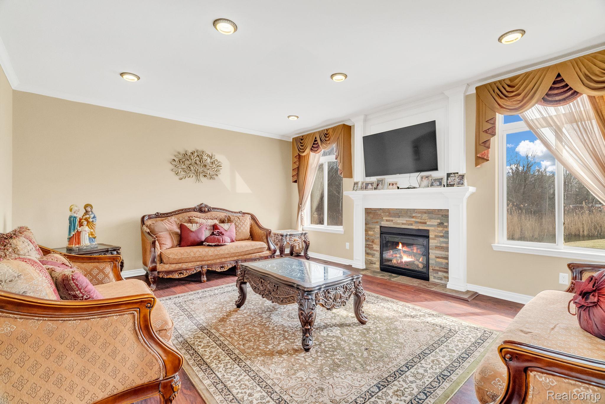 4122 Hawks Nest Road Utica, MI 48317 - Photo 22 of 74 Living area with wood finished floors, a fireplace, and ornamental molding