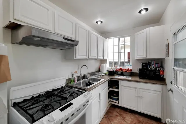 a kitchen with stainless steel appliances a stove a sink dishwasher a refrigerator and cabinets