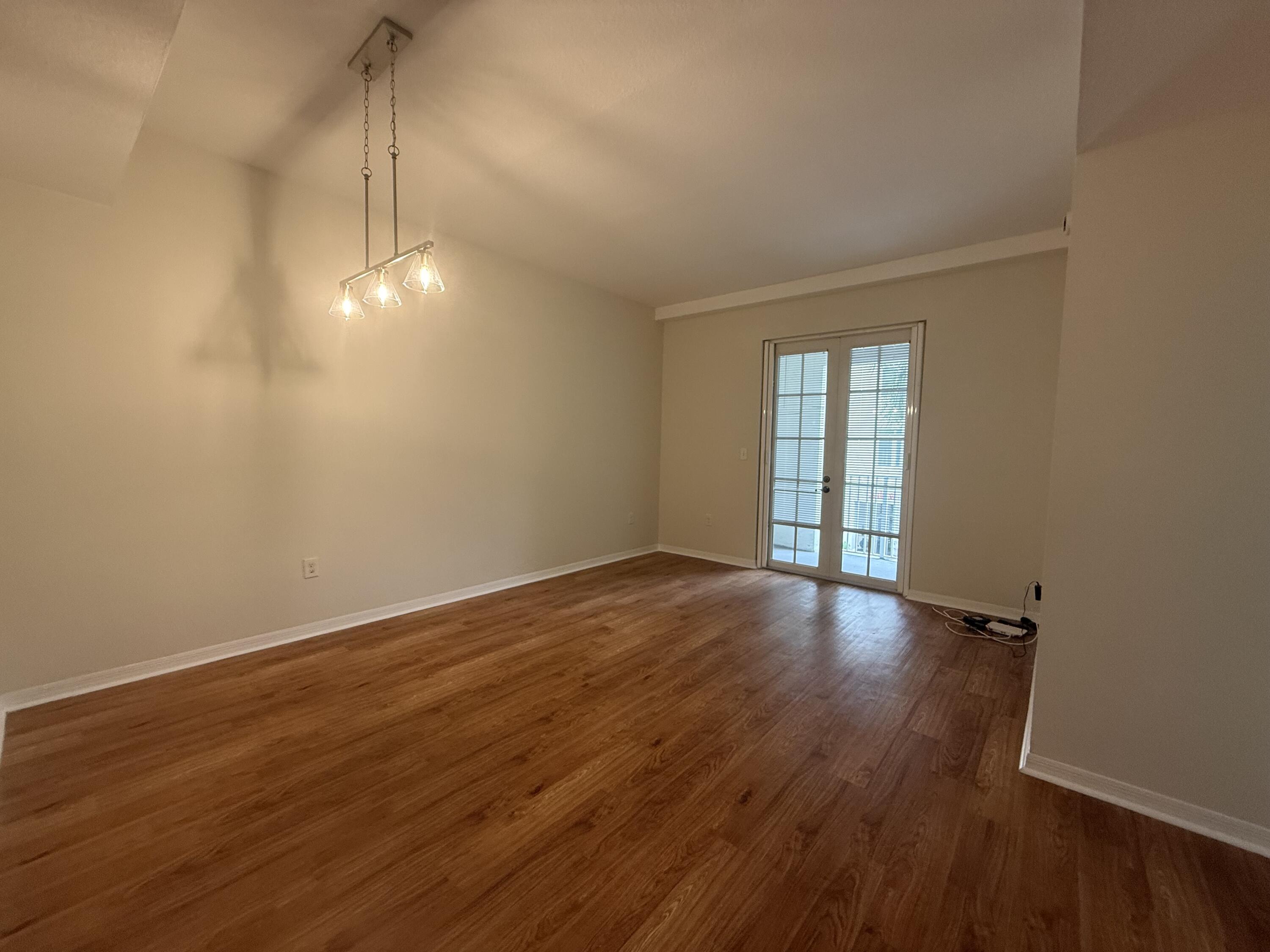 1200 Town Center Drive, Unit 206 Jupiter, FL 33458 - Photo 13 of 24 a view of an empty room with wooden floor and a window