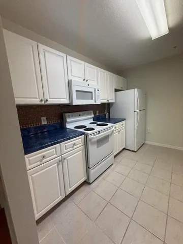 a kitchen with cabinets and white appliances