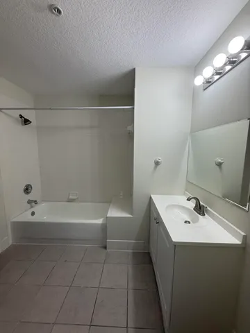 a bathroom with a bathtub a sink a toilet and a mirror
