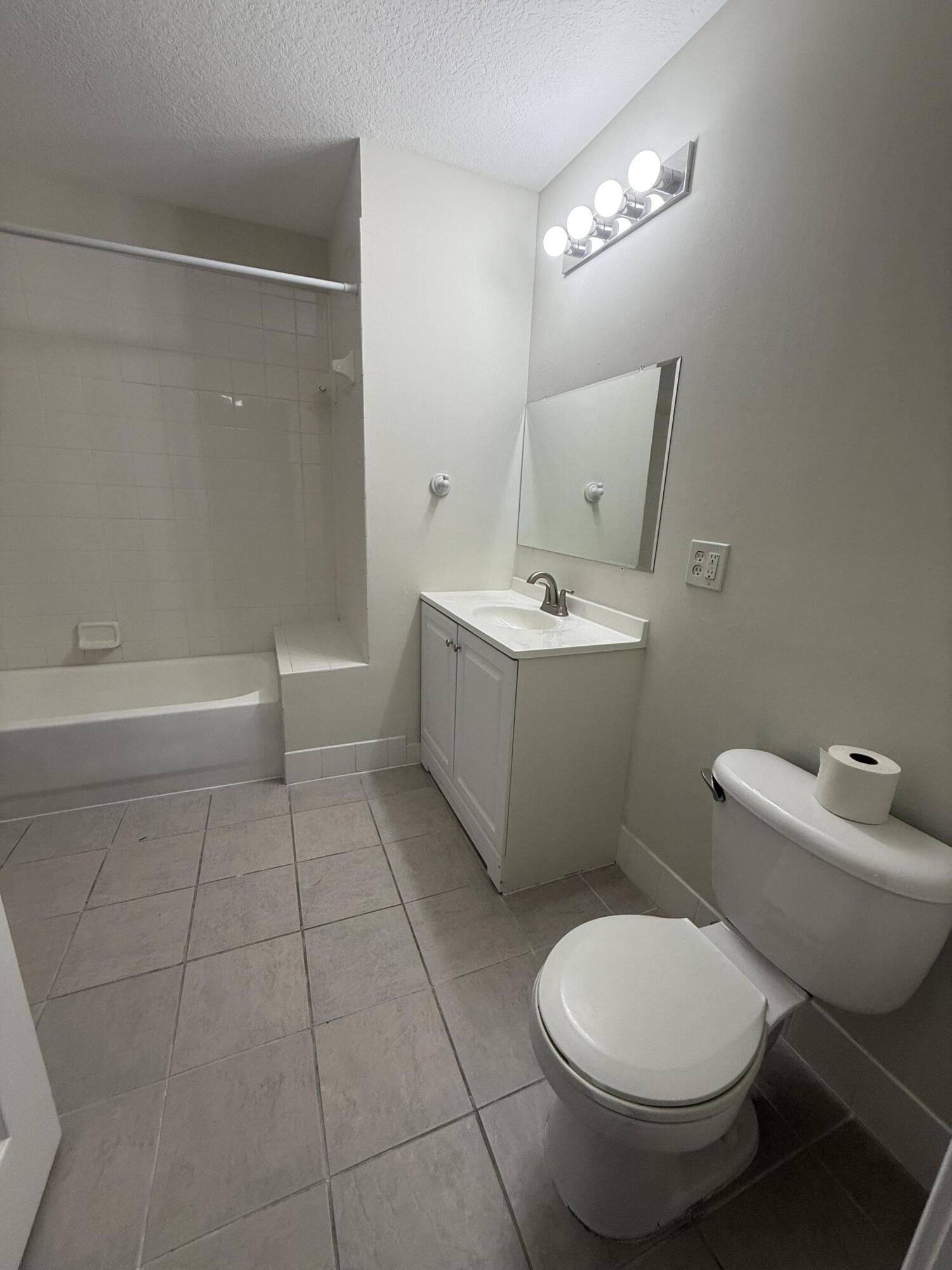 1200 Town Center Drive, Unit 206 Jupiter, FL 33458 - Photo 20 of 24 a bathroom with a toilet sink and mirror