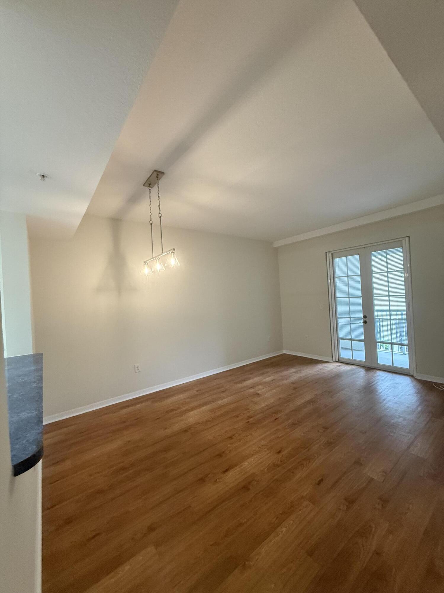 1200 Town Center Drive, Unit 206 Jupiter, FL 33458 - Photo 2 of 24 an empty room with wooden floor and windows