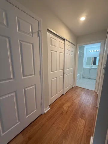 an empty room with wooden floor and mirror