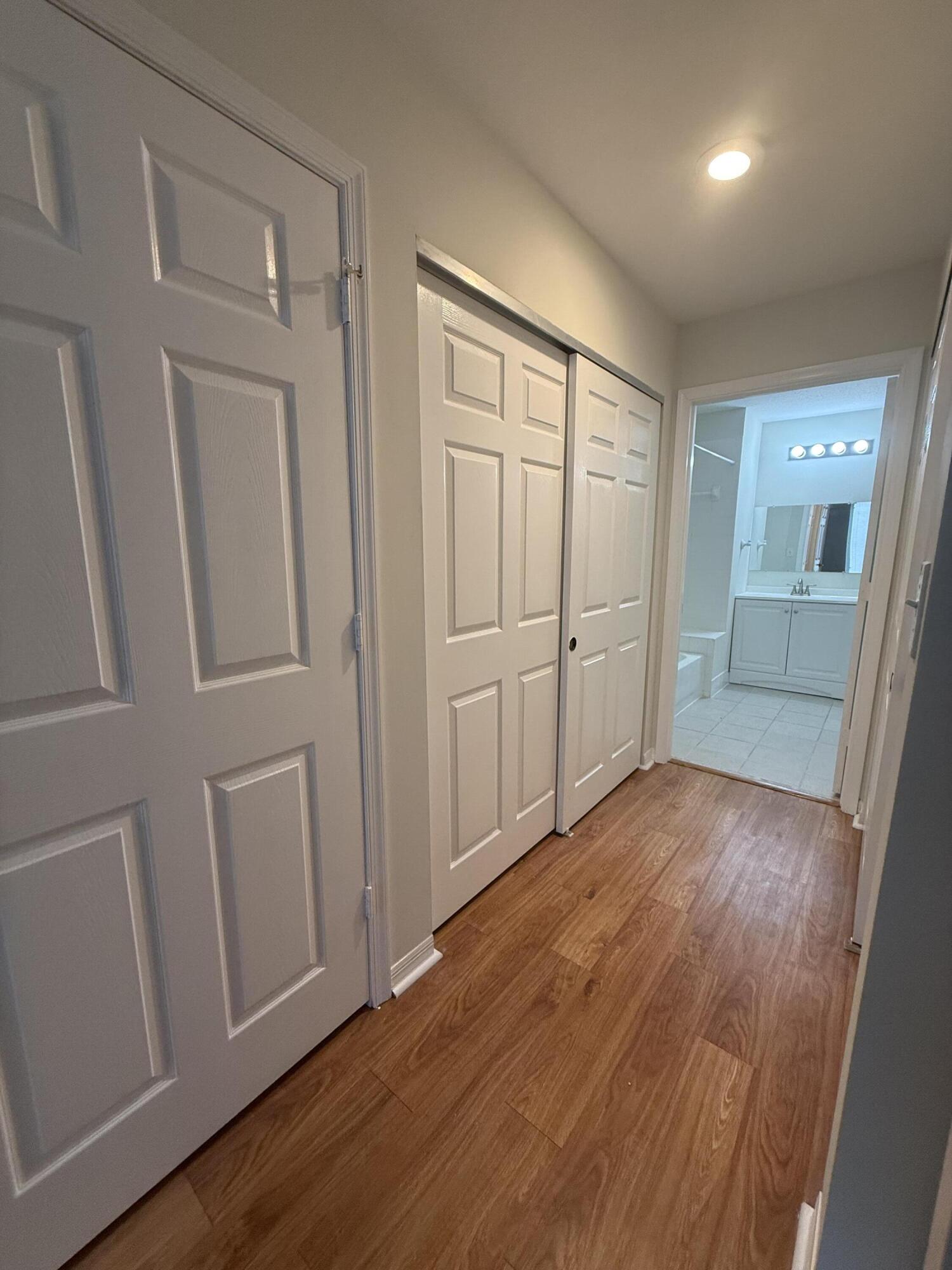 1200 Town Center Drive, Unit 206 Jupiter, FL 33458 - Photo 21 of 24 an empty room with wooden floor and mirror