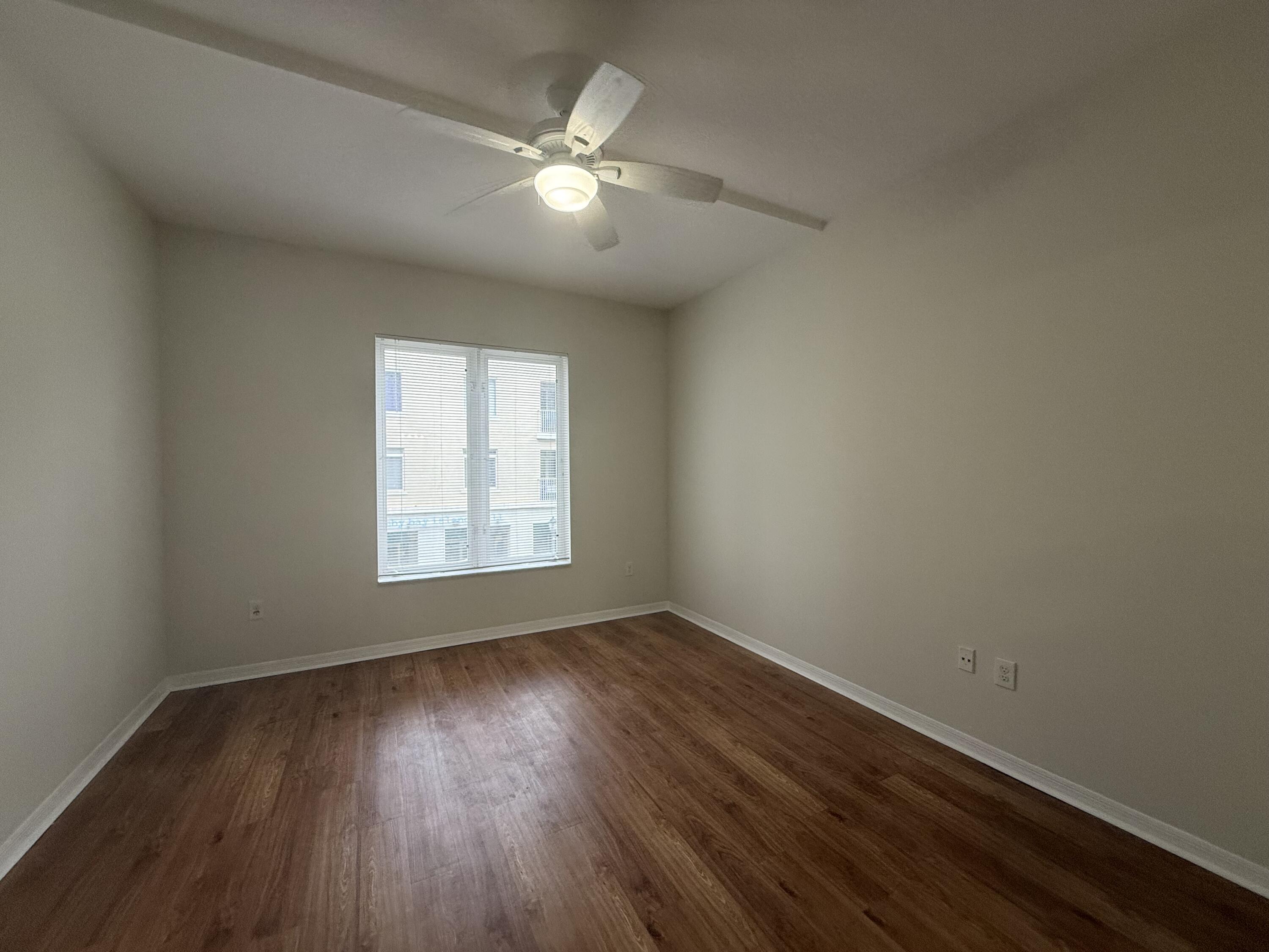 1200 Town Center Drive, Unit 206 Jupiter, FL 33458 - Photo 22 of 24 a view of an empty room with wooden floor and a window