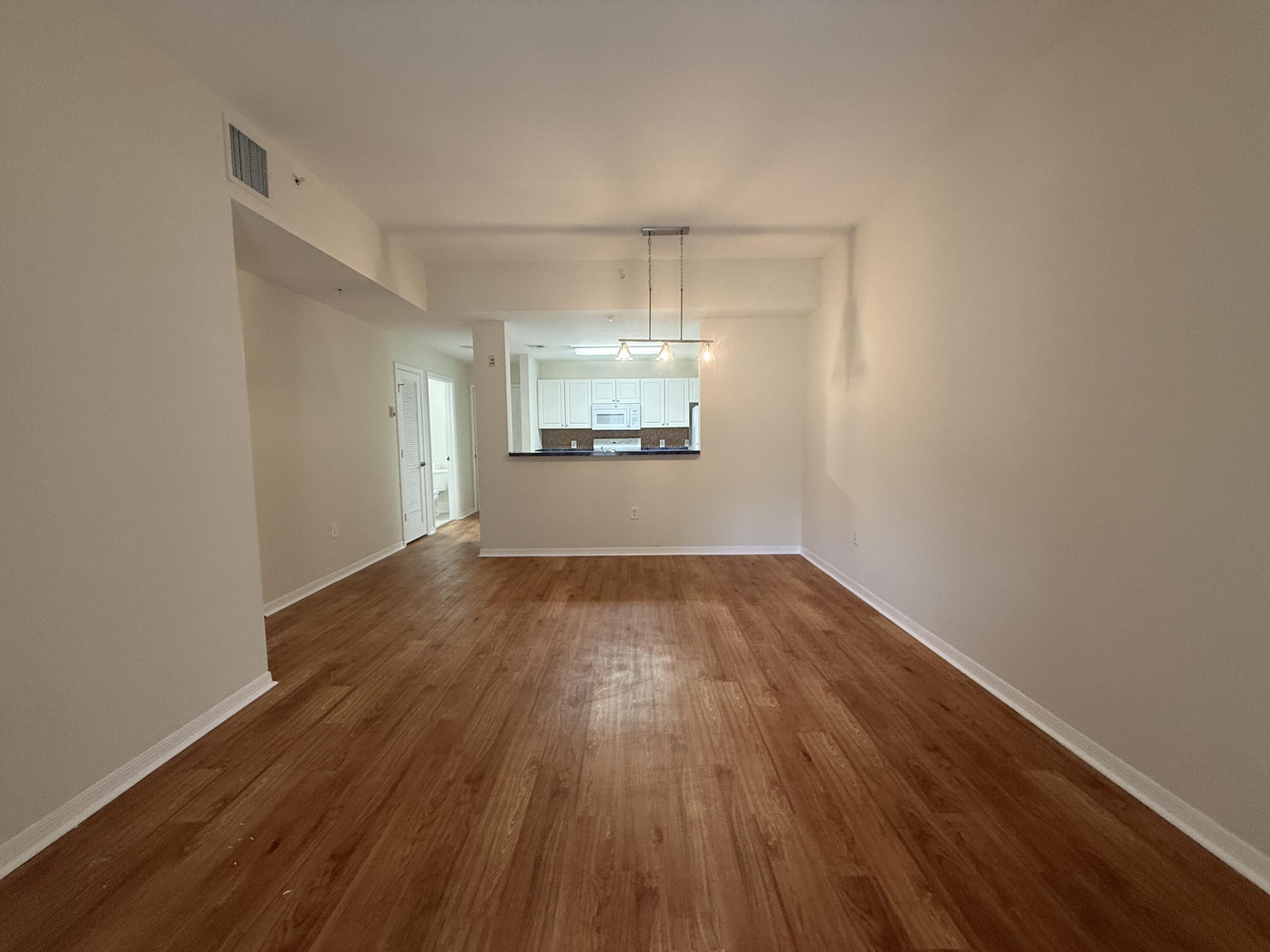 1200 Town Center Drive, Unit 206 Jupiter, FL 33458 - Photo 7 of 24 an empty room with wooden floor and windows