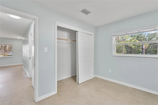 an empty room with windows and closet