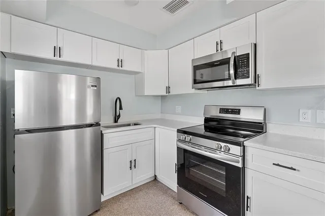 a kitchen with stainless steel appliances a refrigerator sink and microwave