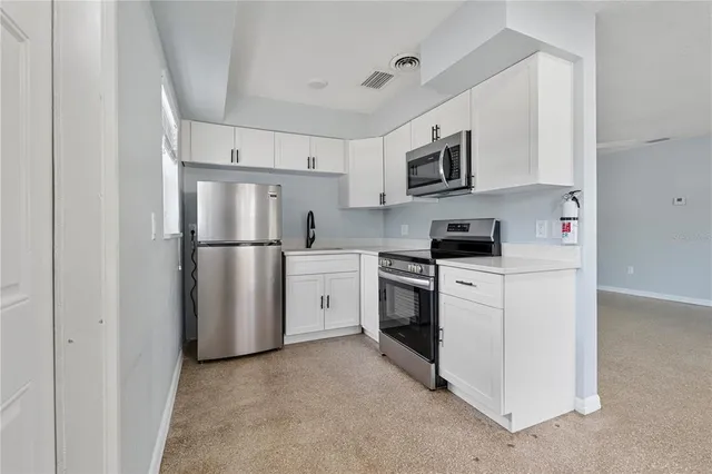 a kitchen with white cabinets and white appliances