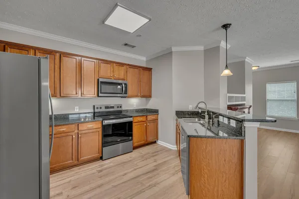 a kitchen with a stove a sink and a refrigerator