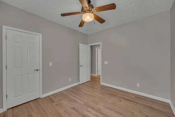 a view of an empty room and chandelier fan