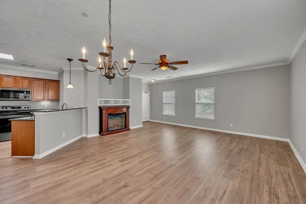 a view of a room with wooden floor and kitchen