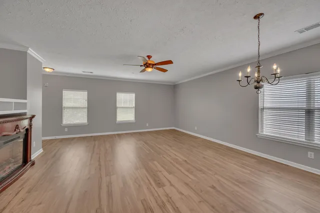 a view of empty room with wooden floor and window